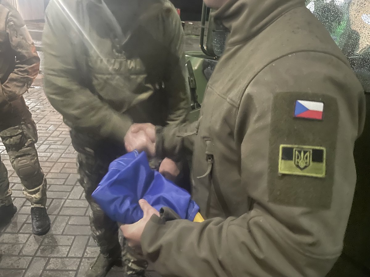 Team4Ukraine1's tweet photo. Operace Humvee sanitky - Dlouhý den 2. část 😴🇺🇦

Jižní kolona Team 4 Ukraine se blíží k městu Umaň, kde je domluvený bod setkání s 🇺🇦 jednotkou mariňáků, pro které bude jeden Humvee a kopa vybavení. To, že toto město bude jen o několik dní později terčem bombardování civilního sídliště s více než 20 mrtvými civilisty jsme netušili. Mariňáci navrhli setkání v tomto městě, protože pro nás by v rámci časového plánu byl Mykolajiv, kde je jednotka rozmístěna, příliš daleko. Druhá skupina se servisním vozem dohání zbytek týmu kousek před městem. Společně parkujeme na benzínové pumpě, kde má proběhnout setkání. Vykládáme z dodávek věci, které chceme krom Humvee a zdravotnického vybavení věnovat rotě mariňáků.

Netrvá dlouho a přijíždí velitel roty Denys, třicátník atletického vzhledu s upraveným vousem. Od pohledu reprezentativní voják. Společně s dalšími dvěma jeho kolegy se zdravíme, postupně se mariňáci seznámí s celým výjezdním týmem. Neztrácíme čas a ukazujeme jim jejich nové „fáro“ k záchraně životů jejich bratrů ve zbrani. Denys umí anglicky, takže nemusíme řešit překládání od našeho Bahdana, což urychluje vysvětlování. Ukazujeme vybavení, které k autu dáváme a vysvětlujeme, jak se co používá. Veliteli roty úplně svítí oči, krom vozu opět největší radost dělají intraoseální vrtačky a jehly. Je milé překvapení, že byť je takový přístroj pro paramediky vzácnost, zdá se že u každé jednotky je alespoň jeden medik nebo doktor, který tuto pomůcku zná a umí ji používat (tedy dokáže to naučit ostatní, když od nás přístroj dostanou). Dáváme klukům také krabici čelovek, powerbank a několik plně vybavených osobních lékárniček tzv. IFAKů.

Bavíme se s Denysem o jeho jednotce, není to jednoduché poslouchat. Bojovali na začátku války u Mariupolu, pak na dalších částech jižní fronty a nyní se připravují na protiofenzívu. Jejich prapor utrpěl za dobu trvání bojů 70% ztráty a tak jsou nyní u jednotky hlavně nováčci, kteří doplnili ztráty z předchozích měsíců. Mariňáci nám vysvětlují, že takové vozy, jako jsme jim dovezli, jsou doslova „božím darem“ a nadějí na záchranu mnoha životů. Slibujeme si dlouhodobější podporu a spolupráci s touto rotou, Denys je za podporu české veřejnosti opravdu moc vděčný. Před rozloučením si dáváme společnou fotografii u Humvee a dostáváme krásný dárek. Hoši nám dovezli vlajku se znakem jejich jednotky a také nám někteří z nich podepsali ukrajinskou vlajku (tyhle věci rozhodně poputují v čechách do muzea).

Humvee spolu s mariňáky odjíždí směr jižní fronta a my nasedáme do našich tří dodávek směr Dnipro, kde máme možnost nocování přes kamarádku obdarovaných mariňáků a taky setkání s reportérem Českého rozhlasu Martinem Dorazínem. Je už notně pozdní hodina, ale máme naštěstí povolení k nočním přejezdům a na blockpostech jde vše bez problému. Na místo setkání dorážíme kolem 02:00 ráno, je to takový omšelý průmyslový areál. Po chvilce čekání skutečně přichází Lena, která nás navádí do areálu. Po zaparkování vozidel (jízda po městě v zatemnění je docela náročná na orientaci), bereme spacáky a malé batůžky z aut a jdeme hlouběji do areálu. Lena nás zavádí do tělocvičny, hle jsme v budově internátní školy! Tu bychom tady opravdu nehledali. Lena a její přátelé nám na podlahu tělocvičny připravili matrace a deky, takže se poprvé od přejezdu polské hranice vyspíme jako lidi. Všichni jsou vyčerpaní a za chvilku je v tělocvičně hrobové ticho, jen Sully a Rošťák si ještě upřesňují plán na další den, ten už budeme trávit ve frontových oblastech v Doněcké oblasti. Dvě čelovky nad mapou po chvíli zhasínají a spát jdou i poslední ze skupiny.

Pokračování zítra…

Líbí se vám naše činnost a chcete také podpořit pomoc Ukrajině? Prosím pošlete nám příspěvek na tento transparentní účet 2801169198/2010 Děkujeme! 🙏