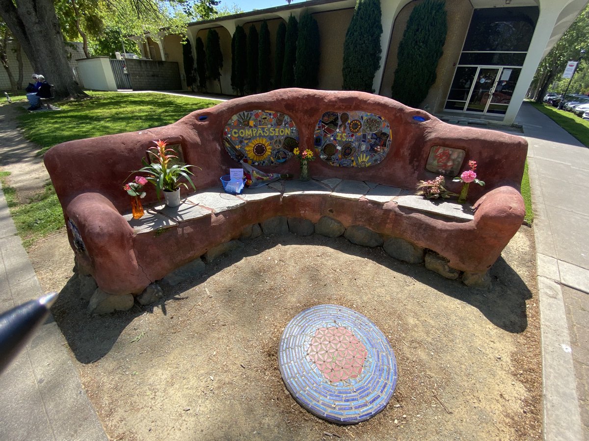 Flowers and kind notes adorn the Compassion Corner Earthbench, a public art space spearheaded by #DavisCA homicide victim David Breaux with contributions from local artists. It was built 10 years ago today. Extra police presence around the park today.