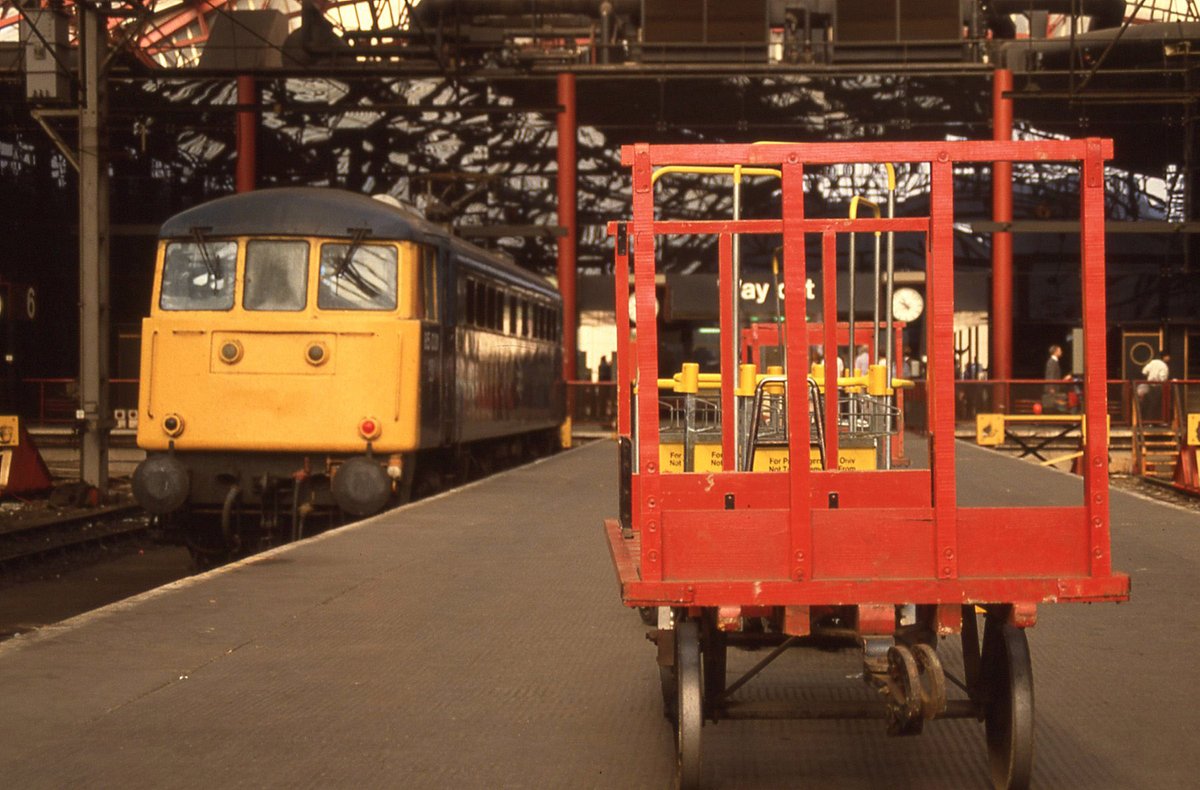 tokerjrh's tweet photo. BR Bonus.  Very occasionally I got a little "arty".  So here is a red luggage trolley with 85031 lurking behind it at Liverpool Lime St 17th August 1988.  #Class85 #BRblue #Britishrail https://t.co/WH84gAf4nx