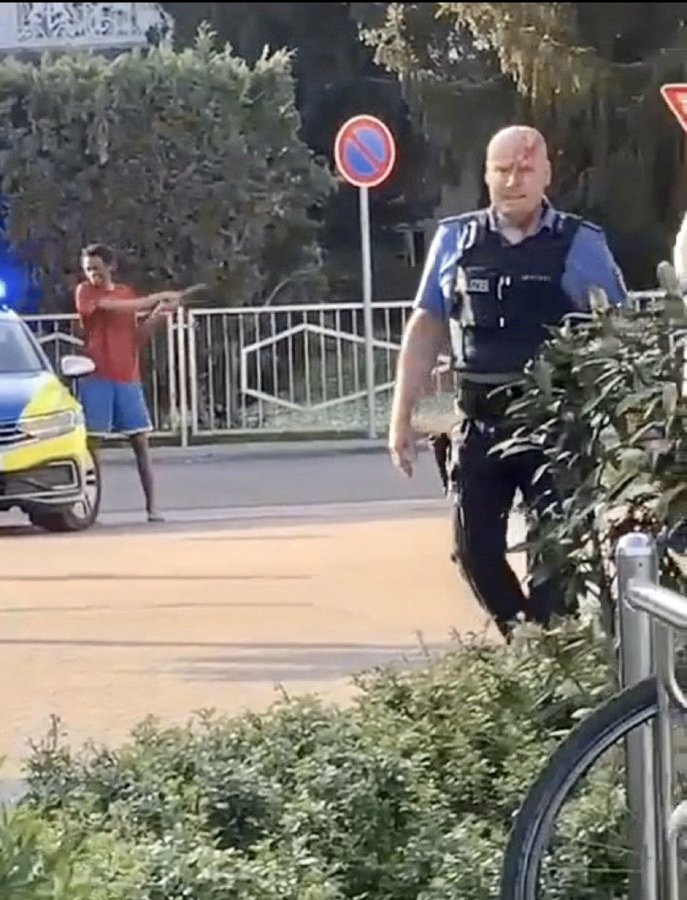Ein geradezu künstlerisches Sittenbild der Bundesrepublik 2023: Ein Polizist, verprügelt mit dem eigenen Polizeiknüppel, irrt ziellos umher während der Migrant die Sau rauslässt