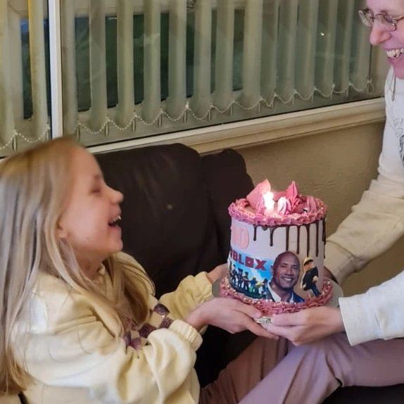 Corrette's tweet photo. @TheRock @MakeAWish ❤️ our 10 year old daughter gets her wish from @MakeAWishUK next month but she would have loved to have met you, she is a huge fan. You were on her birthday cake &amp; she has a framed photo on her desk 🥰 https://t.co/Vj6uNs3rAd