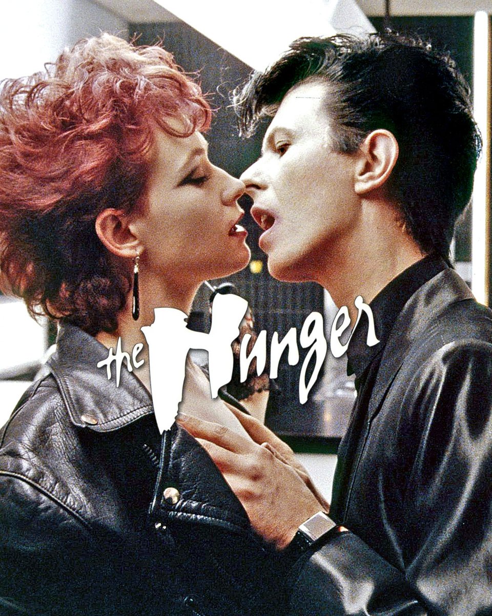 DavidBowieReal's tweet photo. THE HUNGER IS FORTY TODAY

“Please hide from the kiss and the bite...”

Today is the 40th anniversary of the US release of the 1983 Tony Scott directed The Hunger.

Bowie is pictured here as John Blaylock, a 200-year-old vampire retaining his youthful good looks with the help of blood sucked from young people, such as the unsuspecting victim here.

John is the latest in a string of specially chosen humans stretching back over millennia, who have been promised eternal life as vampire lovers of Miriam Blaylock (Catherine Deneuve).

Eternal life isn’t quite as described by Miriam as it doesn’t mean eternal youth. When John starts rapidly ageing, he seeks the help of Dr Sarah Roberts (Susan Sarandon) and things start getting complicated.

Anything more would be considered a spoiler, so if you haven’t seen The Hunger, check it out at the earliest opportunity. Possibly the sexiest and most stylish vampire movie of all time.

Meanwhile, to mark the anniversary, https://t.co/3kz7K1SfcA has posted an X-Rated Version of the opening scene recut to an edit of Bauhaus Bela Lugosi’s Dead, from the 1982 live album, Press the Eject and Give Me the Tape.

As Nacho points out, David Bowie said of this scene: “the first twenty minutes rattle along like hell - it really is a great opening.”.

We’re dutybound to point out that though it was an X-Rated (18) film originally, it seems it’s now a 16+, so please bear that in mind before viewing: https://t.co/S84loqIBa9

#BowieTheHunger