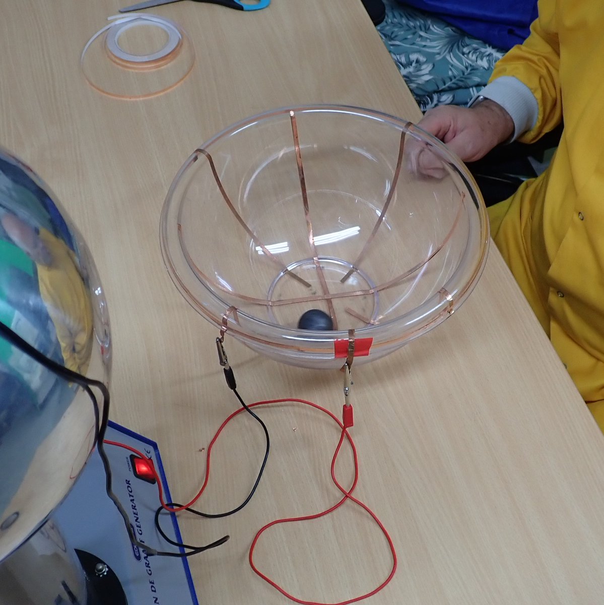 PhilipMRussell1's tweet photo. 🌀 Trying out a cyclotron! Made from a mixing bowl, copper tape &amp; powered by a Van de Graaff generator⚡. The Ping-pong ball circled the bowl, but not too fast 🏓💨 #DIYcyclotron #sciencefun https://t.co/idoKBNlHW3