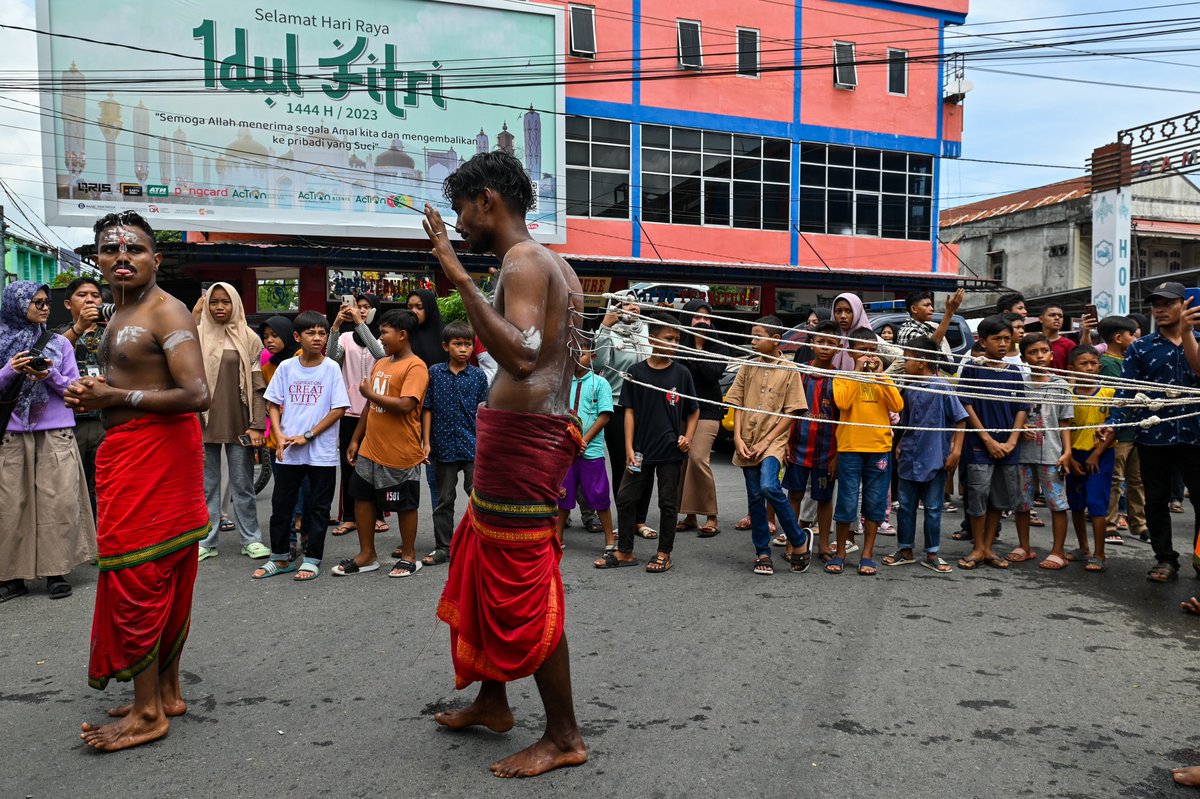 Indonesian ethnic Tamil Hindu devotees take selfies before participate in last day of a traditional 'Chithirai Mahapuja' procession in Banda Aceh on April 30, 2023, the first time religion procession after three years due to the Covid-19 pandemic.