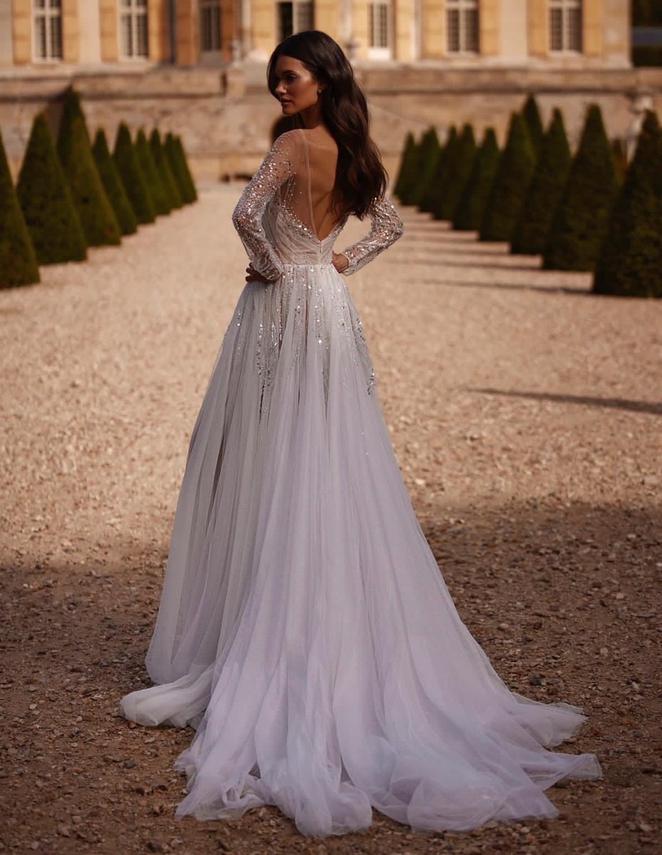 Xiaothao_Hong's tweet photo. This fairytale #MillaNova wedding dress features a beautiful draped bodice with illusion sleeves adorned with light-catching sequins, beads and pearls detailing with a flowing glitter tulle skirt. https://t.co/WKjvCwbjXq https://t.co/QCx4QiLMoX