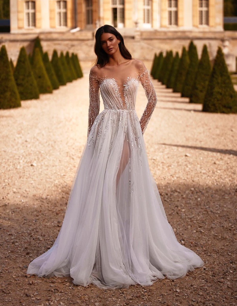 Xiaothao_Hong's tweet photo. This fairytale #MillaNova wedding dress features a beautiful draped bodice with illusion sleeves adorned with light-catching sequins, beads and pearls detailing with a flowing glitter tulle skirt. https://t.co/WKjvCwbjXq https://t.co/QCx4QiLMoX