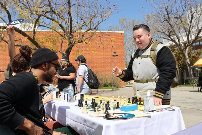 Philosophy table: student and rep playing chess together