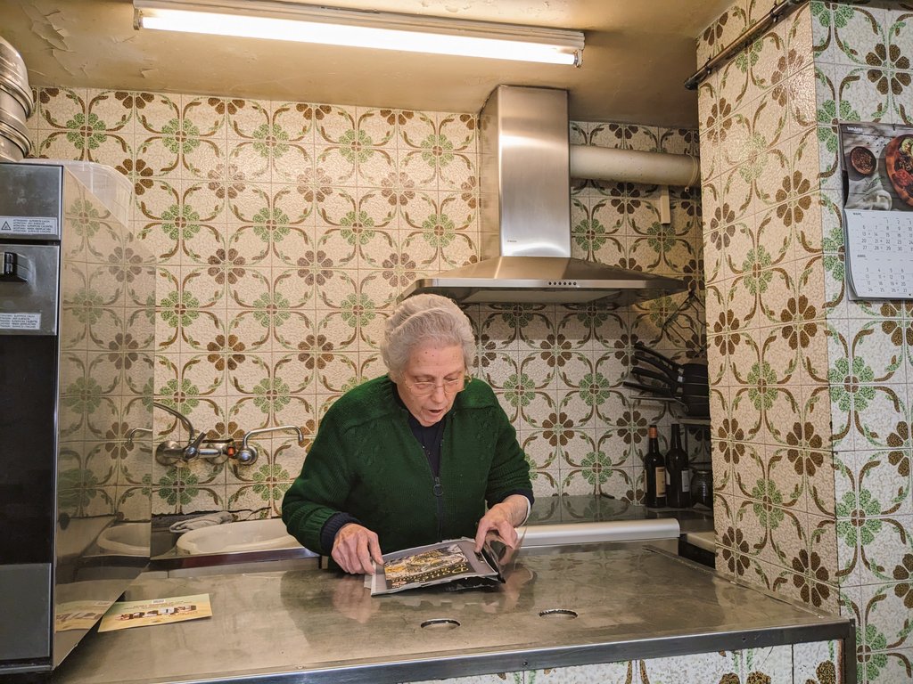 BarnaCentre's tweet photo. Avui la senyora Montserrat, ja a porta tancada, feia memòria entre retalls de diari i petits agraïments a tota una vida d'esforç. Sap que la trobarem a faltar. El Brusi era un dels establiments únics del barri i part d'un model comercial que lamentem perdre. https://t.co/rcocLybTH2