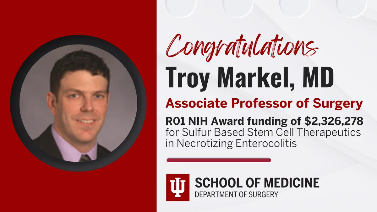 Profile picture of Troy Markel, MD, with a black circular frame against IU crimson background. Right side: text reads - Congratulations Dr. Troy Markel, Associate Professor of Surgery, R01 NIH award funding of over $2million. Research topic: Sulfur based stem cell therapeutics in necrotizing enterocolitis. Red line below text on a white background. Bottom right IU horizontal logo that reads School of Medicine Department of Surgery. 