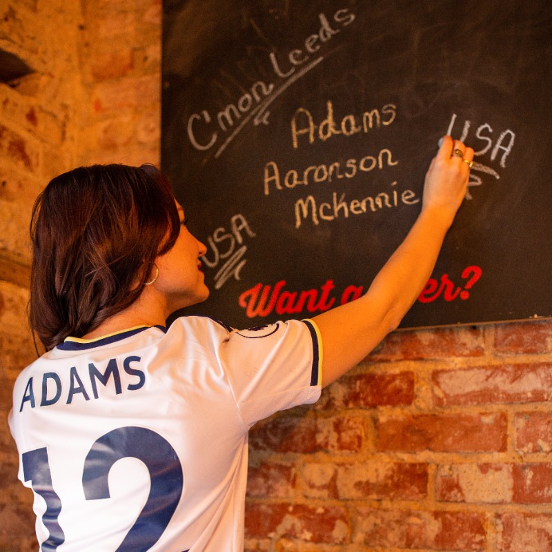 PLinUSA's tweet photo. Wearing your club's kit under your work clothes to demonstrate your passion? That's a tradition we can get behind 👕

Meet @beckycllns88, a @LUFC fan and pharmacist in Fort Worth, Texas, who turned tweets about her favorite @ussoccer players into #PL fandom.

#PLFansofAmerica