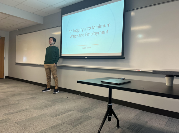 Adam Reiter gives a presentation on how minimum wage and the employment rate correlate using different labor markets. #Quest