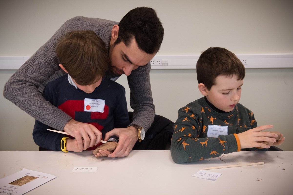 assyr_u's tweet photo. The importance of learning cuneiform at an early age! With ⁦@MirkoSurdi⁩ and ⁦@akkadicat⁩ ⁦@ugent⁩’s children’s university #alumnidag https://t.co/iLtfnFOims