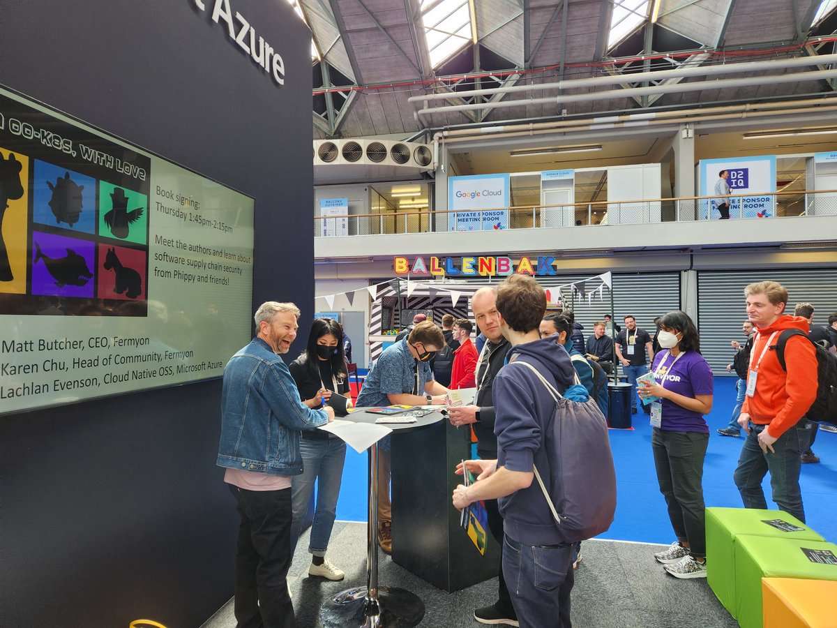 cskimming's tweet photo. Happening now! Swing by the Azure booth at #KubeConEU for a free, signed copy of From 00K8s, With Love! @LachlanEvenson, Karen Chu, &amp; Matt Butcher 🦒🦓 https://t.co/nyMZHeR4Am