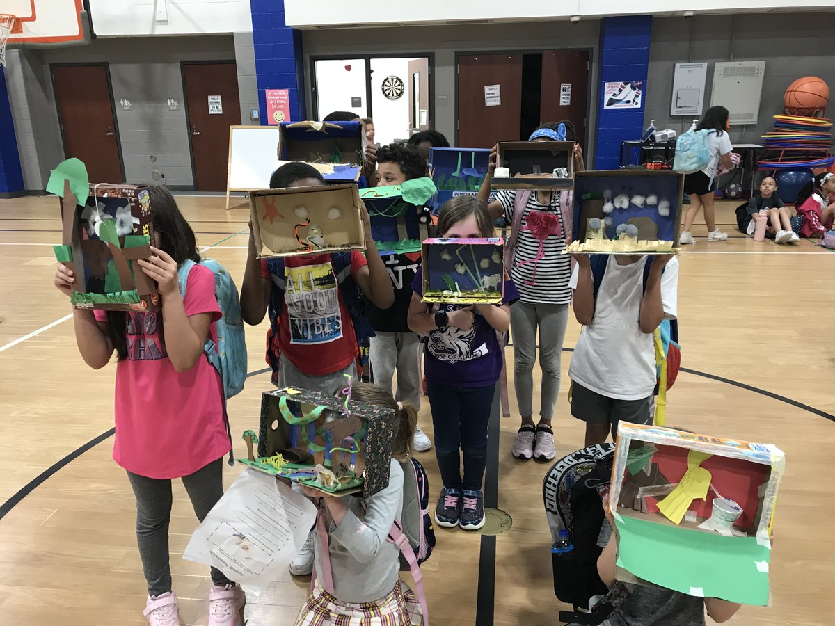 1st grade students showing off their natural habitats the made in class. 🥰
