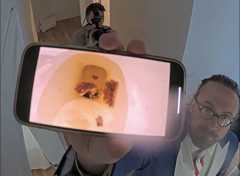 fishtankdotlive's tweet photo. Est FT 11:57 PM: Mr Goldstriker enters the tank. Jason finds unflushed faeces in the toilet and shows a photo to the upstairs hallway cam. https://t.co/ySMVEPEiFk