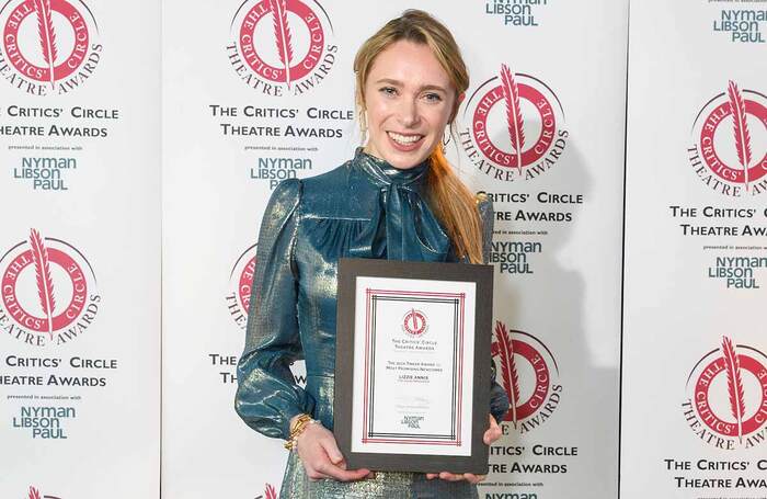 Lizzie Annis holding her award at The Critics' Circle Theatre Awards