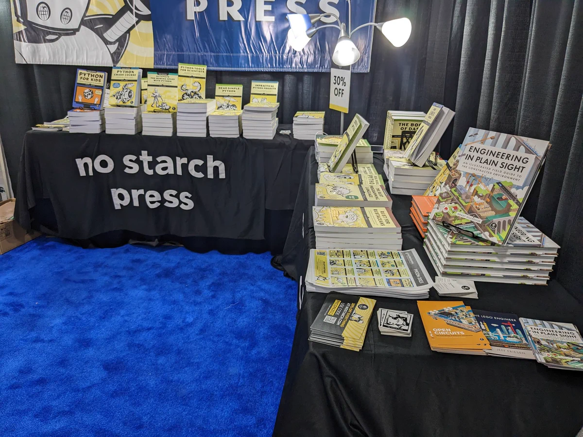 Photo of books displayed at conference for purchase. The book "engineering in plain sight" is shown in a sea of python books