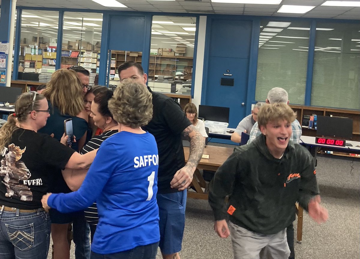 Anderson High School Principal Tom Safford gets hugs after the district board of trustees voted to reinstate him as principal.