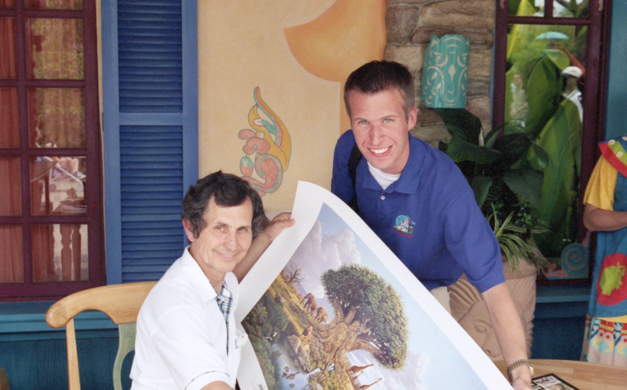 Clive Kay holding a poster of his artwork with Steven.