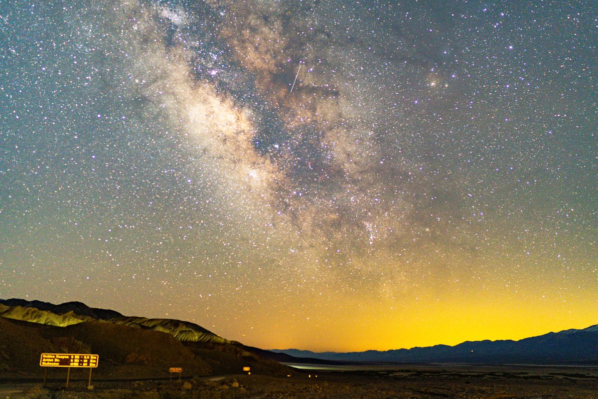 samjezak's tweet photo. The Milky Way stretches out over the road to Badwater Basin, the lowest point in the US. The vastness of the galaxy meets the vastness of the desert. https://t.co/ZbZROY2ppJ