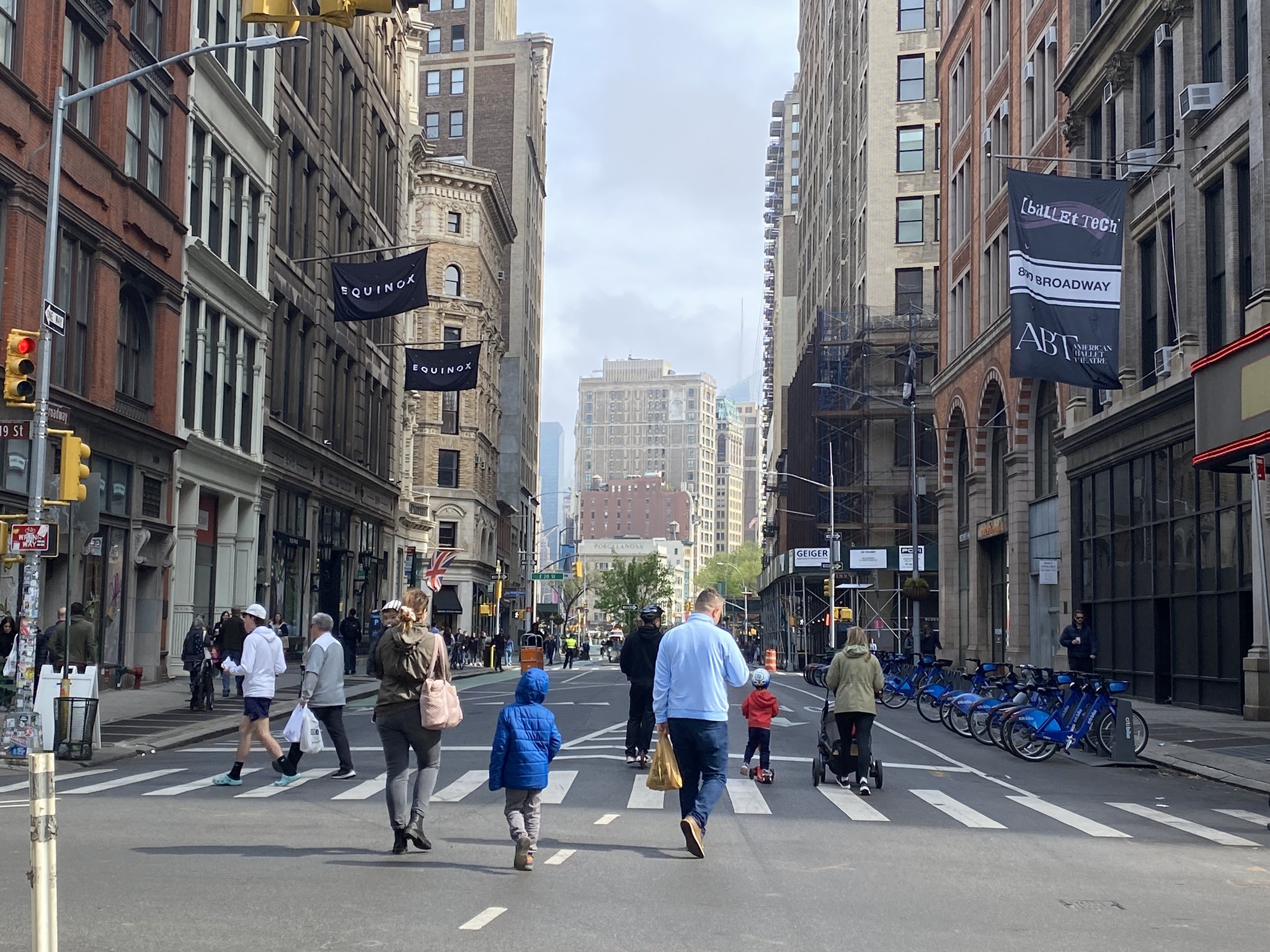 People walk and scoot on a car free street