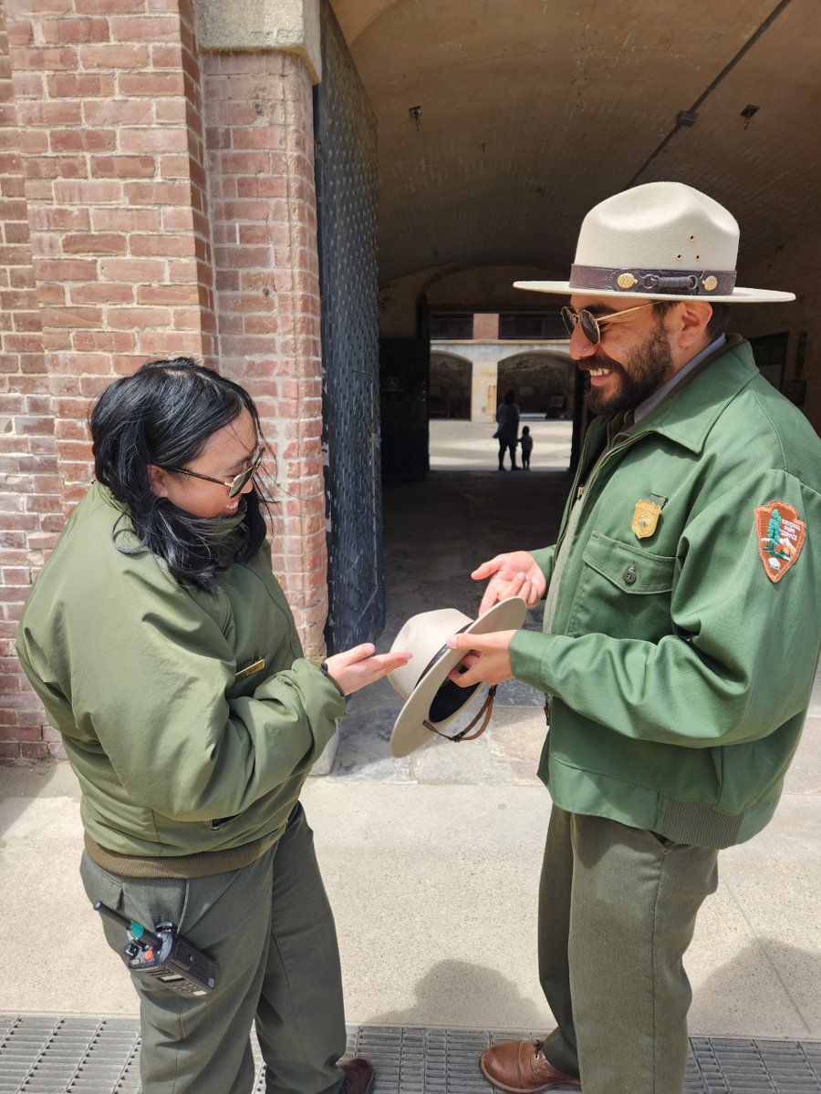FortPointNHS's tweet photo. One amazing thing about being a ranger is having people pass down traditions to you. Here we have Ranger Alejandro showing Ranger Carmen the old tradition of how to tie a hat band. Now Ranger Carmen will show the next generation. This is the way.

#NationalParkWeek #ThisIsTheWay https://t.co/L9WFnLyAa2