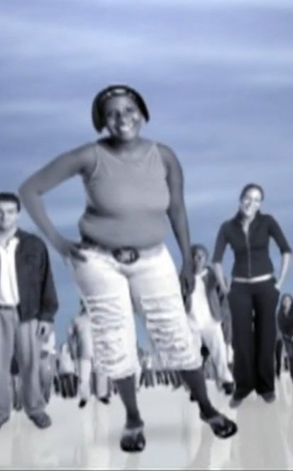 estático em baixa qualidade de mulher negra sorridente com pinta de diva em preto e branco na abertura de senhora do destinho, ela veste uma blusinha de alcinha, uma tiara no cabelo chanelzinho, um jeans branco rasgado, aparenta ter 40 anos, o fundo e azulado e com outras pessoas em preto e branco paradas.
