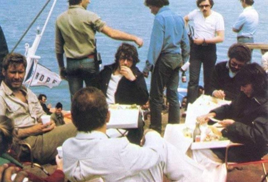 Great behind the scenes snap from RAIDERS OF THE LOST ARK. Harrison Ford, Steven Spielberg, George Lucas, and Karen Allen having lunch together.