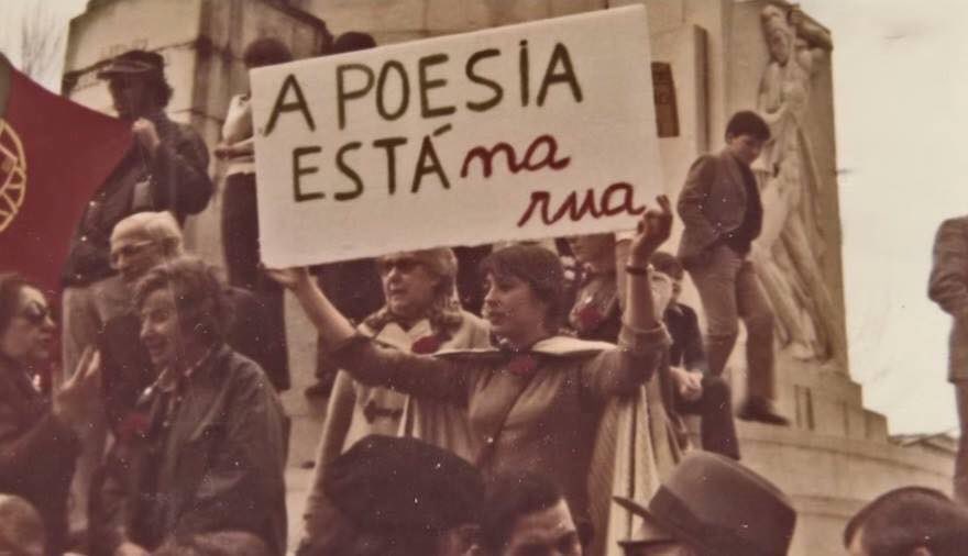 A poesia está oficialmente na rua. 49 anos do 25 de Abril de 1974

(A cineasta Margarida Gil segura o cartaz com a frase de Sophia de Mello Breyner Andresen, que daria a origem a um dos mais icónicos cartazes do 25 de Abril de 1974)