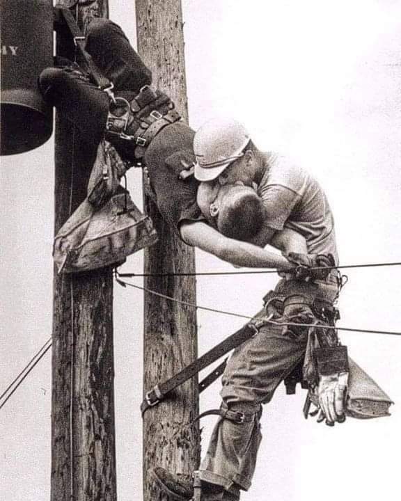 InformaCosmos's tweet photo. El "Beso de la Vida". 🤯

Esta galardonada foto de 1967, tomada por Rocco Morabito, fue titulada "El beso de la vida". Muestra a dos operarios eléctricos, Champion Randall y JD Thompson, en la parte superior de un poste de electricidad.

Ellos habían estado llevando a cabo el mantenimiento de rutina cuando Champion rozó una de las líneas de baja tensión en la parte superior del poste de electricidad.

Más de 4.000 voltios entraron en el cuerpo de Champion y al instante se detuvo su corazón (una silla eléctrica utiliza alrededor de 2.000 voltios).

Su arnés de seguridad evitó una caída, y Thompson, que había estado ascendiendo por debajo de él, rápidamente lo alcanzó y se realizó la respiración boca a boca.

No fue capaz de realizar la reanimación cardiopulmonar, dadas las circunstancias, pero continuó la respiración boca a boca, manteniendo activos los pulmones de Champion hasta que sintió un ligero pulso, a continuación, se desabrochó el arnés y descendió con él sobre su hombro.