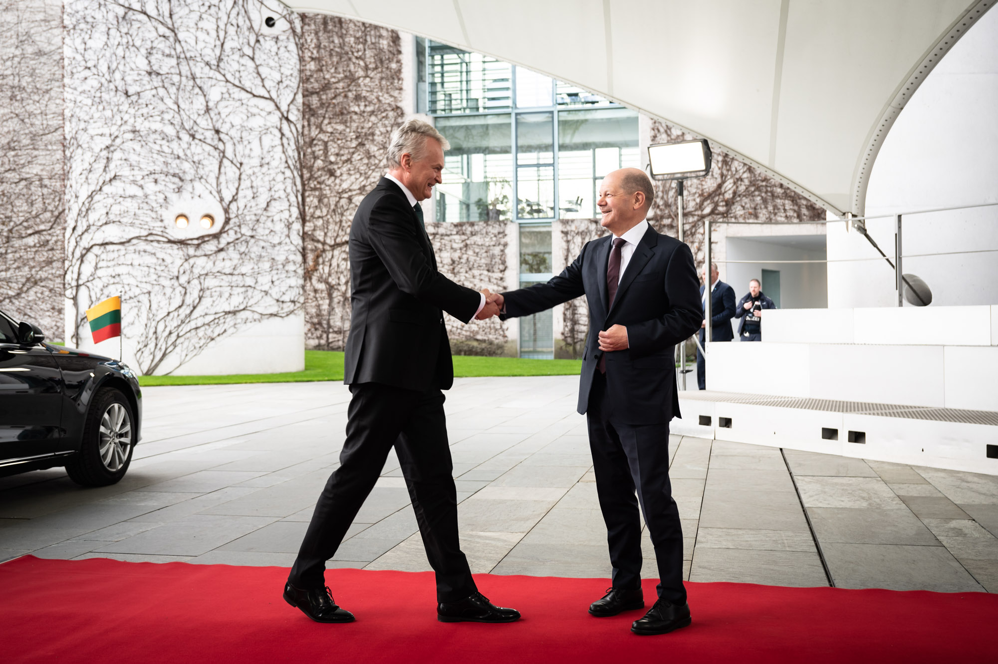 Bundeskanzler Scholz empfängt den litauischen Staatspräsidenten Nausėda vor dem Bundeskanzleramt. Zu sehen sind die beiden auf einem roten Teppich, beim Handschlag.