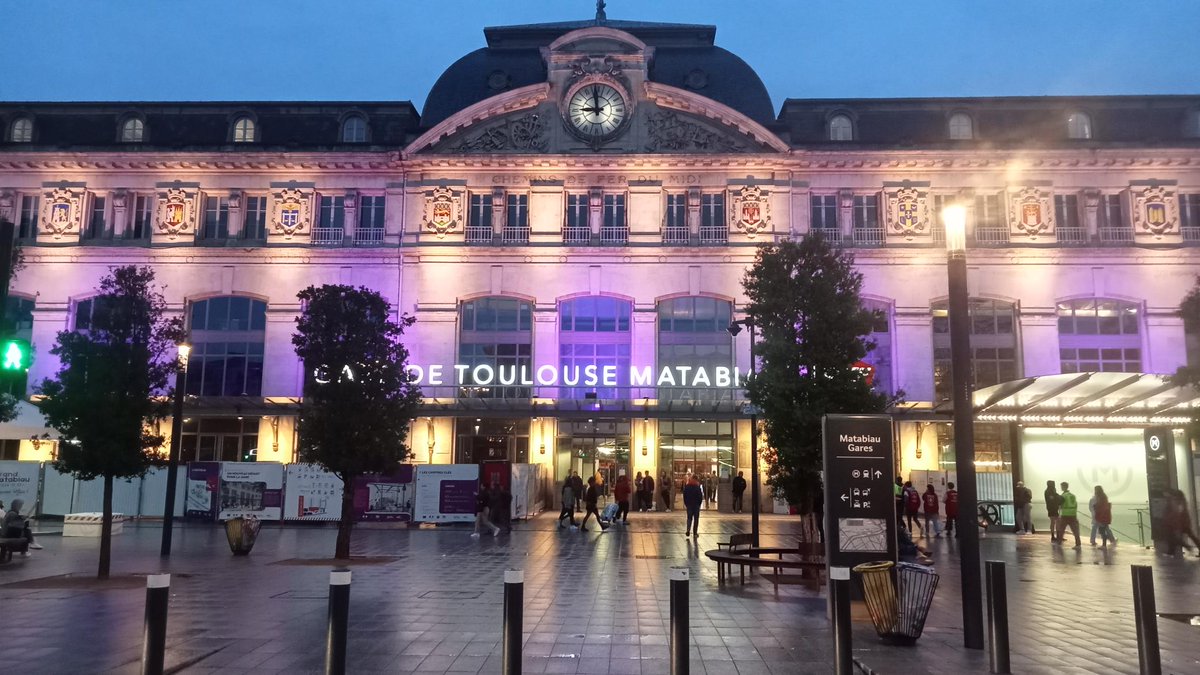 Façade de la gare de Toulouse Matabiau éclairée en violet