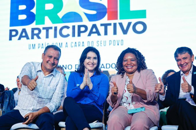 Ministros Rui Costa, Simone Tebet, Margareth Menezes e Wellington Dias sentados e sorrindo para a foto. Fazem sinal de positivo com os dedos