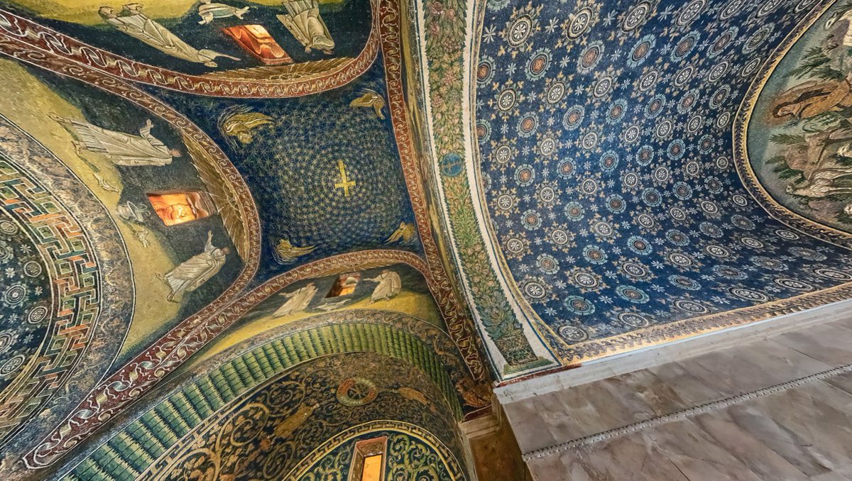 SdStendhal's tweet photo. 📍, 🇮🇹.

⛪️ : Uno de los mosaicos paleocristianos mejor conservados a día de hoy es el del Mausoleo de Gala Placidia, realizado en Rávena en el año 402, dedicado a Cristo (representado en uno de los brazos de la cruz).

El precioso color azul oscuro de las teselas es el que más salta a la vista y cautiva al visitante del mausoleo, combinado con estrellas doradas y en la cúpula central una cruz latina con la idea de su exaltación, la divinidad de Cristo y su venida apocalíptica.

En las esquinas aparecen las representaciones alegóricas de los tetramorfos y en la parte superior de los muros, bajo la bóveda parejas de santos vestidos de blanco alrededor de palomas que beben metafóricamente de la fuente, simbolizando el alma cristiana en el paraíso.

Sin duda es una espectacular obra de arte, en materiales y escenas con gran minuciosidad de detalles, no solo en los santos y los evangelistas sino en algunas representaciones como las margaritas, rosas fantásticas, hojas de parra, y grecas en las que vemos la influencia clasicista de Roma y Grecia.