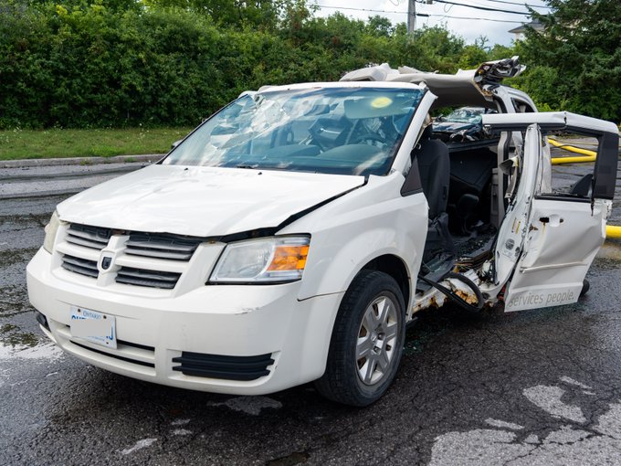 Photo of badly damaged white family van.