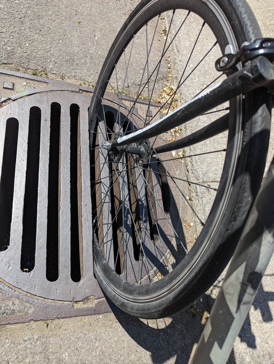 TheBikingLawyer's tweet photo. Sewer grates angled the wrong way are a huge hazard. Had a client whose elbow was seriously fractured as a result. This is on McNabb S of Mulberry @cityofhamilton. These are 28x700c tires, not the slimmest. As cyclists are pushed to the curb by pickups this becomes a real hazard. https://t.co/QFI8ZrKd2w