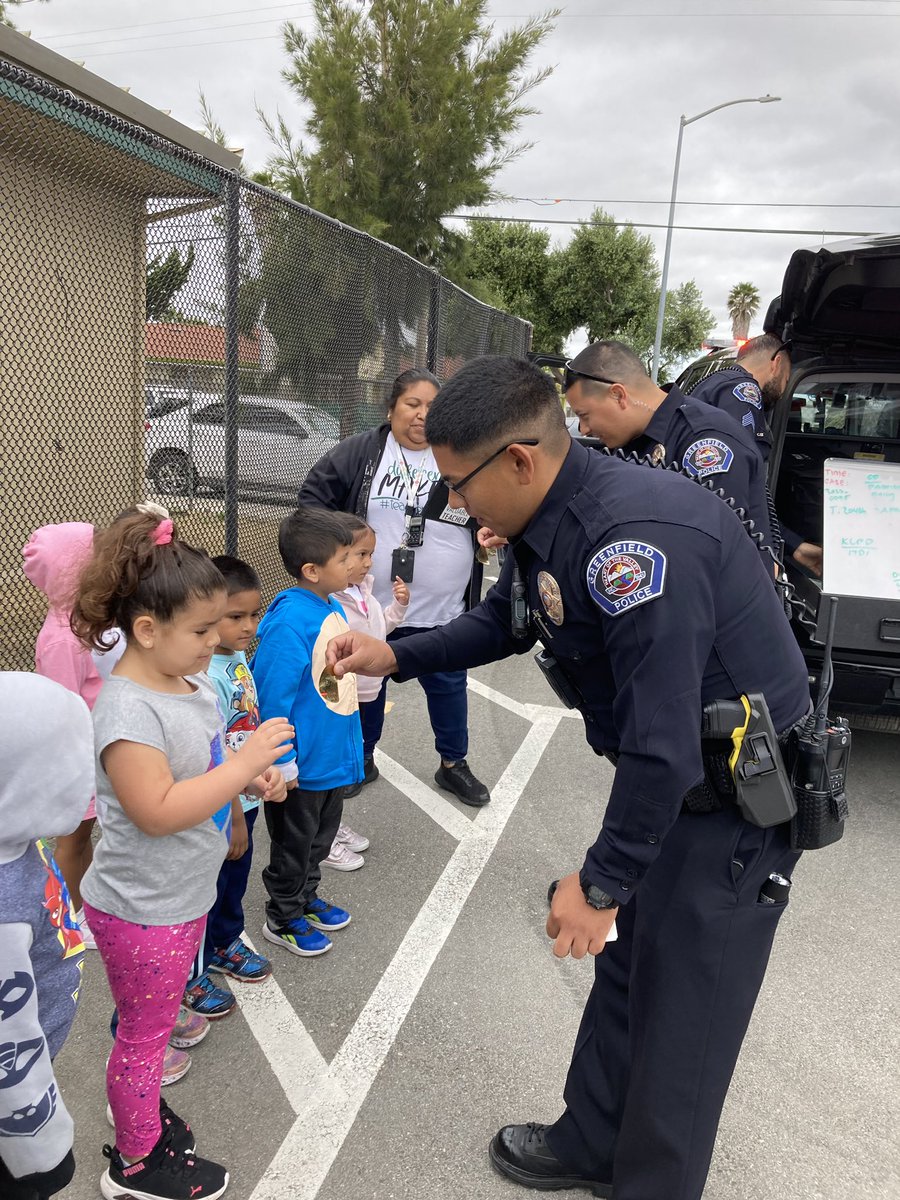 Greenfield Police Department visits Oak Avenue Preschool to educate students on safety and stranger danger. Students explore police cars and equipment and receive badges and coloring books as reminders of safety. #CommunityEngagement #SafetyEducation #GreenfieldPD