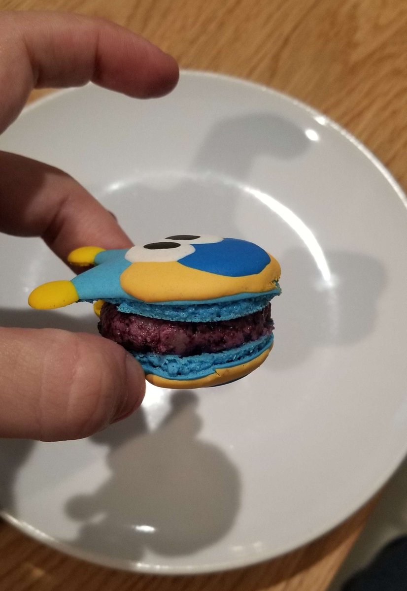 Micarocks101's tweet photo. HOLD IT! Made some Bluto Blue Badger macarons for #thepapergallery , featuring @Bluto2U2 's cute design! The macaron is filled with a blueberry cobbler buttercream, made with blueberry jam and bits of buttery pie crust in the buttercream around a dollop of MORE blueberry jam. https://t.co/os8E5Bf3Fo