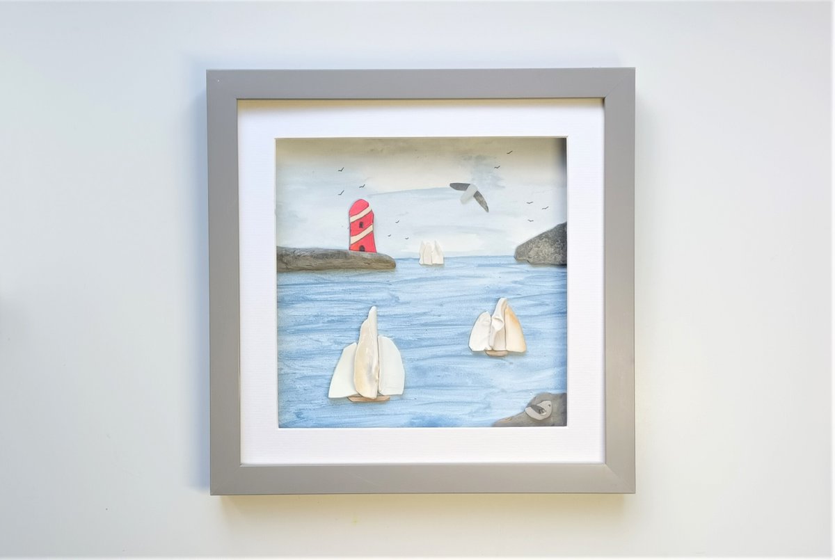 Beachstreetart's tweet image. Sea shell sails sailing past a sea pottery lighthouse in a 29cm square frame #seashellart #seapottery #coastal #walldecor #beachcombed #beachart etsy.com/uk/beachstreet…