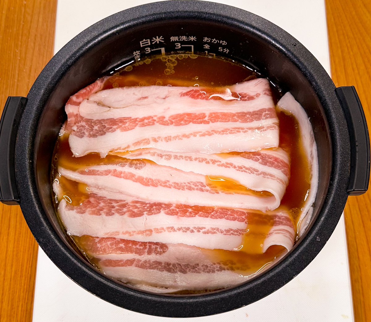 marumi_kitchen's tweet photo. 【豚バラで鶏がらしょうゆ炊き込みご飯】

豚肉のジューシーさと鶏がら醤油が相性抜群！

【材料】
豚バラスライス　200g
醤油 大さじ2
鶏がらの素　大さじ1
ごま油　大さじ1
にんにくチューブ　2cm
白米　2合
※きざみねぎ
※黒こしょう
（炊飯器は3合炊きマイコンタイプ）

作り方の詳細→

【作り方】
①白米を洗ったら醤油、鶏がらの素、ごま油、にんにくチューブを投入
②2合の線まで水を入れたらよく混ぜる
③全体を覆うように豚バラスライスを敷き詰めたら通常炊飯スタート
④お茶碗へもりつけたらお好みできざみねぎ、黒こしょうをふって完成