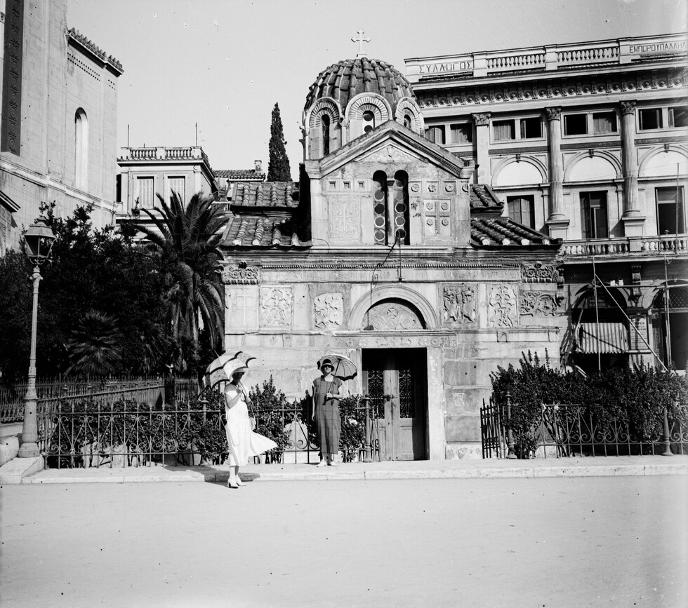 cycladian's tweet photo. Two women (tourists) stand infront of the Holy Church of Panagia Gorgoepikou in Athens. The photograph was taken back in 1924. This unique monument was completely built using ancient stones from earlier buildings, ranging from classical Antiquity to the 12th—13th century. ❤️‍🔥 https://t.co/wfBhWTPkOn