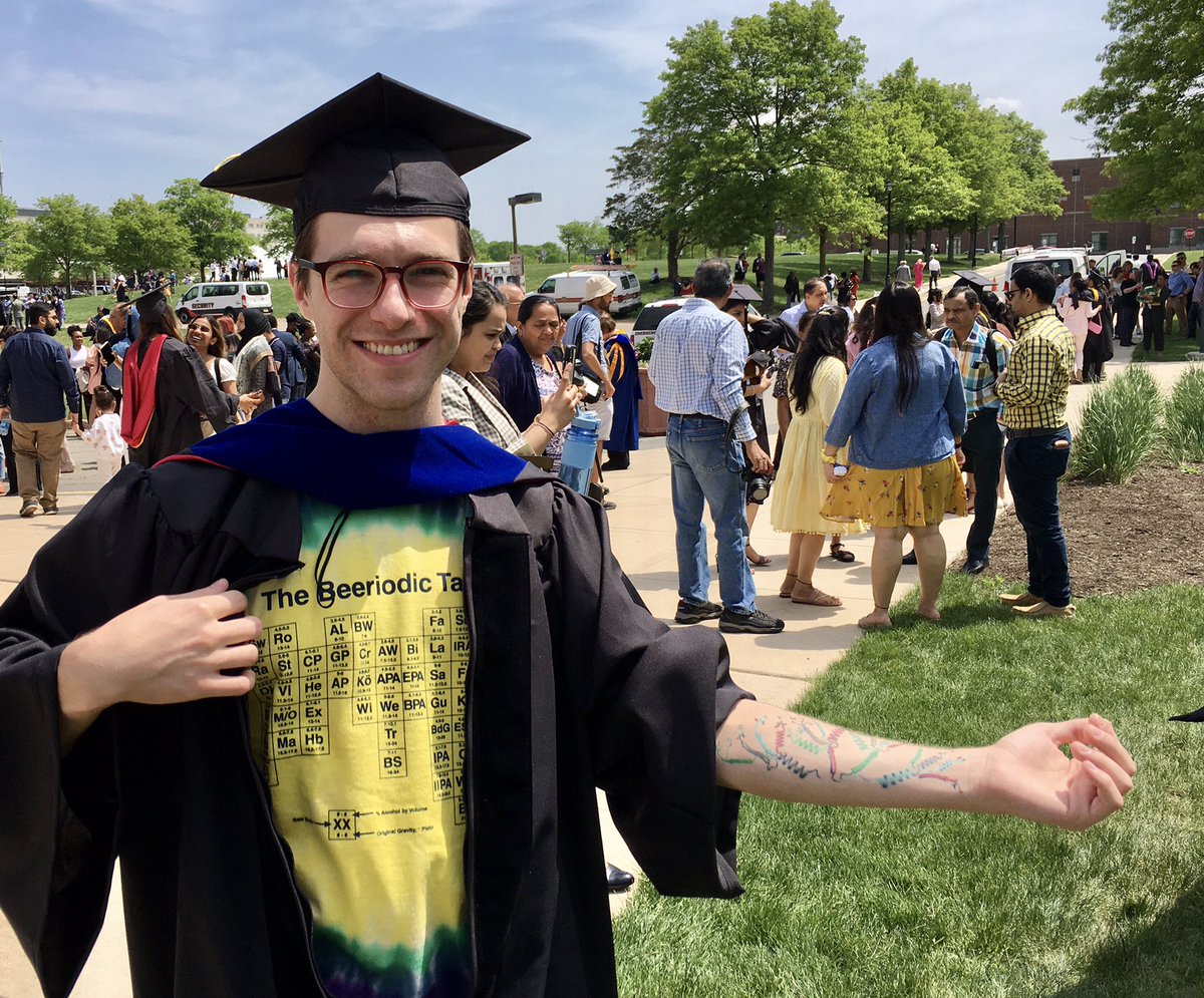 Ryan Dikdan receives his Ph.D. With a periodic table on his chest and the genetic code on his arm and each with a twist, he is going back to medical school to finish his MD.
