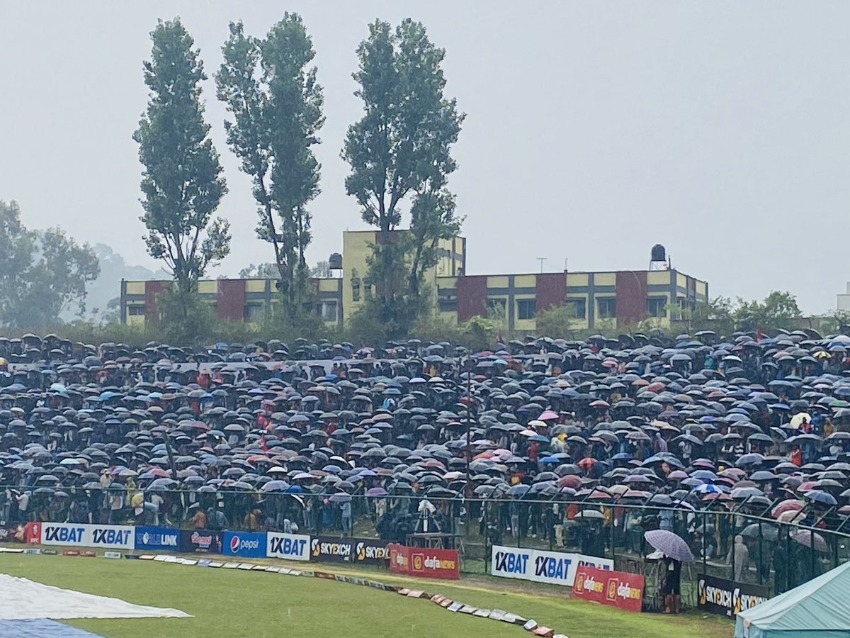 PaulRadley's tweet photo. A phalanx of brollies on the bank at TU. Heavy rain has arrived with Nepal all over UAE. 106/9 https://t.co/pv4D0VFUJZ