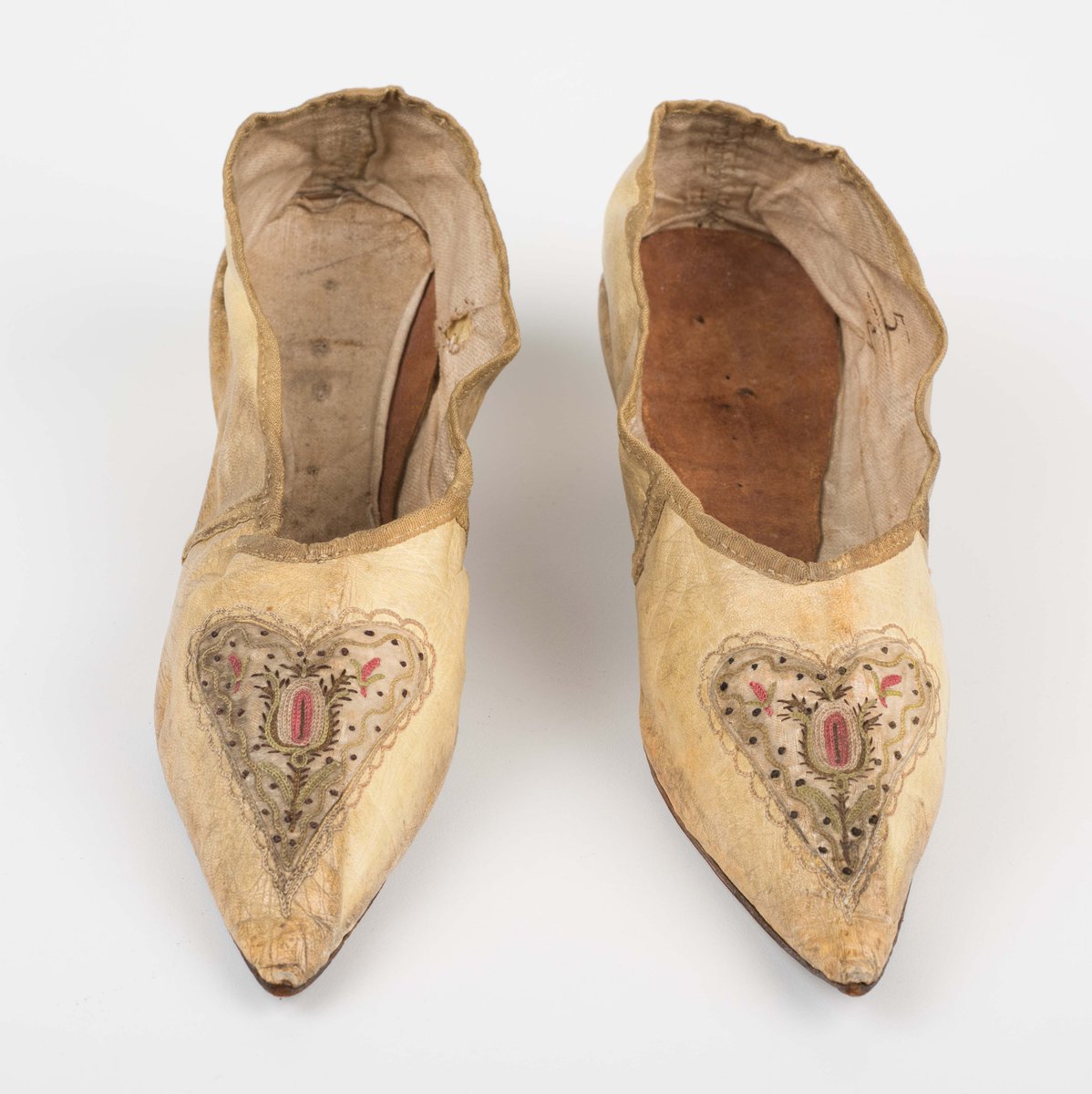 HOW CUTE? 😍 These are court shoes made of embroidered yellow leather, with a pointed toe & Italian heels, 1795. They were also made straight! Although technology existed to make differently shaped left & right shoes, they didn't become popular in England until the C19th.