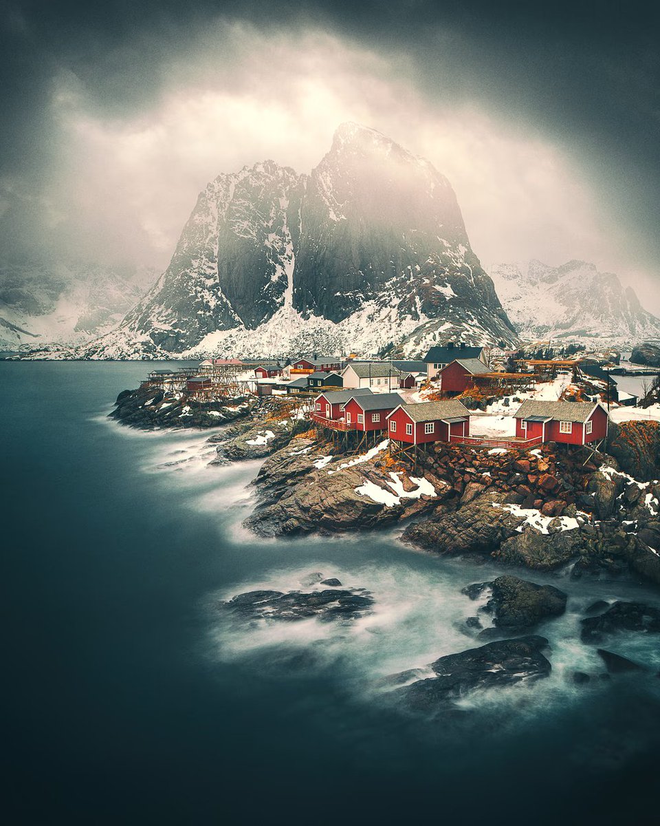 Gm!

The vibrant red fishing huts look like tiny embers 🔥 in the vastness of the turbulent sky. Protected by the unwavering mountain, Like a spiritual guardian, it watches over them amidst the chaos of the storm.