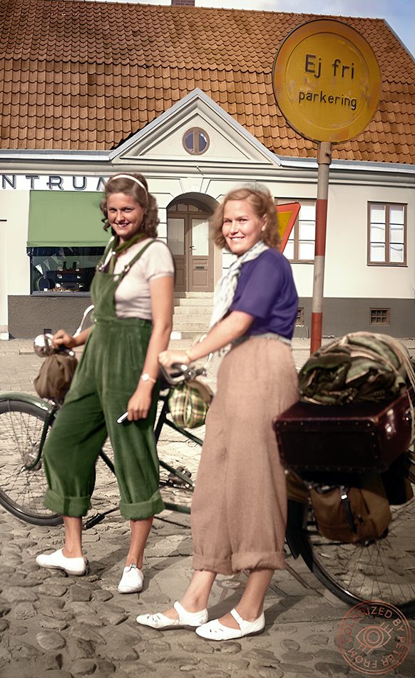 Två unga kvinnor med en tandem som är packad för en cykelresa 1936. Tyvärr är fotografen okänd, liksom flickornas identitet och platsen där bilden togs. De ser glada och fulla av förväntan ut. Kanske har de hela sommaren framför sig?
Kolorerad av mig. RT:a gärna - det uppskattas.