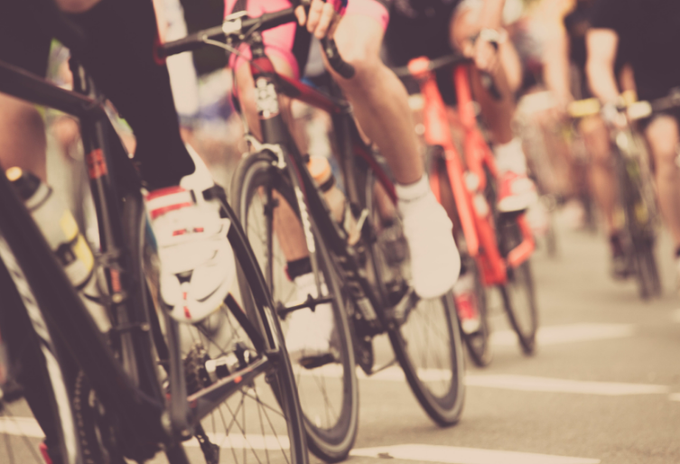 A close up of a line of bicycles as they speed pass.