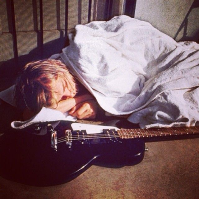 Kurt Cobain sleeping with his guitar.  Photo by Kirk Weddle