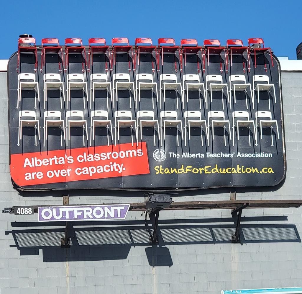 carmenglossop's tweet photo. Happy #RedforEdAB Friday everyone. To kick off the ATA's LPEO and LCO meeting, we held a mini protest fighting for smaller class sizes. Notice behind us is one of the 3D billboards with real chairs on it. I also honor Red Dress Day @albertateachers #SmallerClassSizes #MMIWG2S https://t.co/4kYk34qsFL