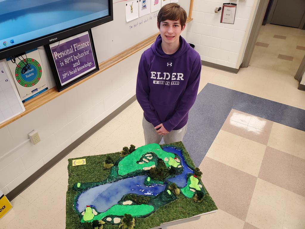 Will Timmerman '25 pictured with his 3D Art masterpiece, "The Final Three." His work will hang out in <a href="/ElderHighSchool/">Elder High School</a>'s room 4 until the end of the school year. Hopefully, it inspires the Personal Finance scholars to fully fund those Roth IRAs, retire early and hit the links.